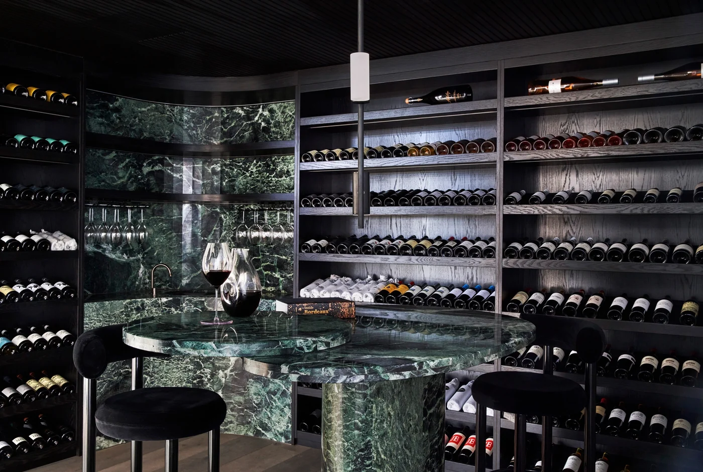 Deep green stone paired with dark timber and warm display lighting