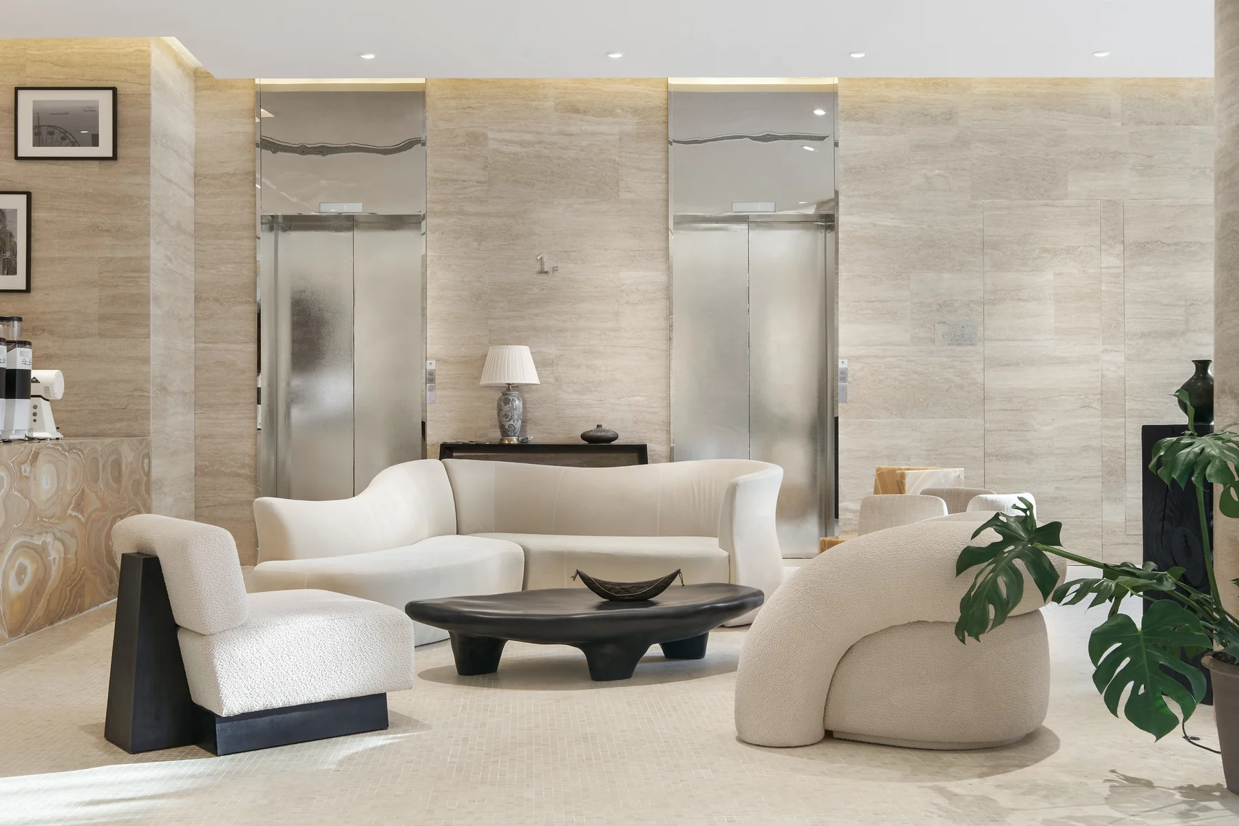 Light-filled interior with a calm natural stone wall behind soft seating